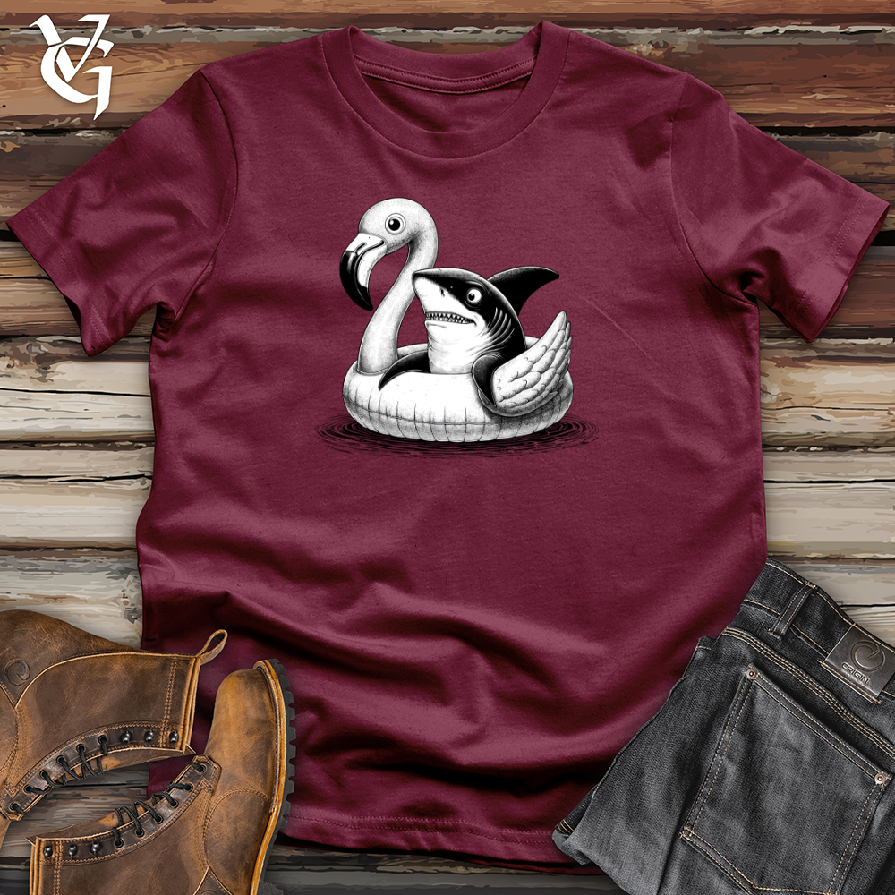 A Shark laying on top of a Flamingo Softstyle Tee